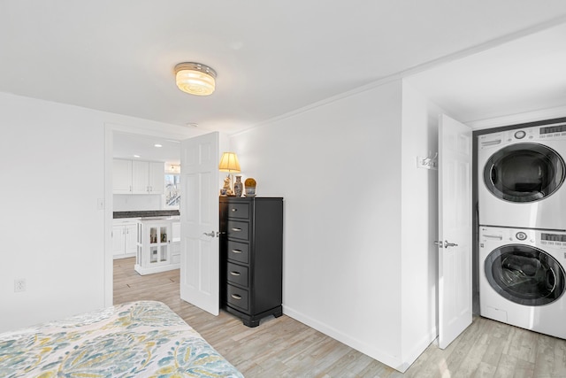 laundry area featuring light hardwood / wood-style floors and stacked washer and dryer