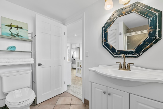 bathroom with toilet, tile patterned floors, a shower with door, and vanity