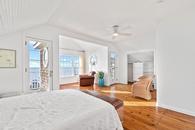 bedroom featuring ceiling fan, access to outside, a closet, lofted ceiling, and wood-type flooring