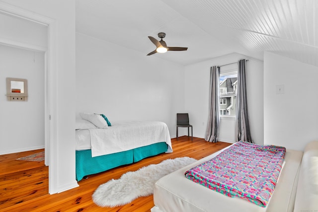 bedroom with ceiling fan, wood-type flooring, and vaulted ceiling