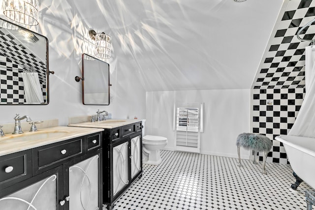 bathroom with vaulted ceiling, toilet, an inviting chandelier, and vanity