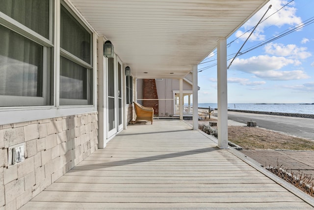 wooden deck with a view of the beach and a water view