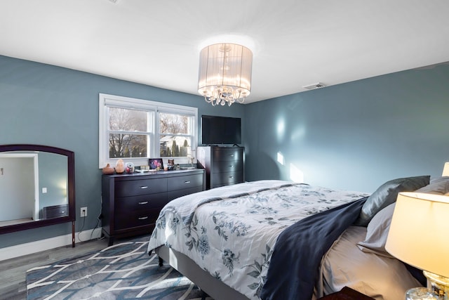 bedroom with a chandelier and dark hardwood / wood-style floors