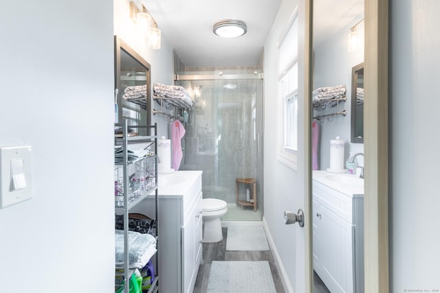 bathroom with toilet, a shower with door, and vanity