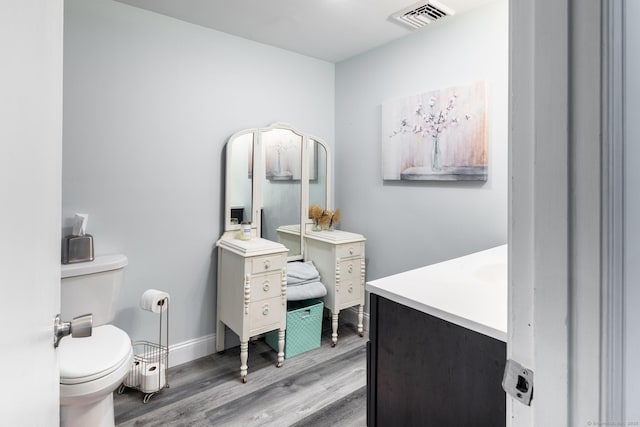 bathroom with toilet, wood-type flooring, and vanity