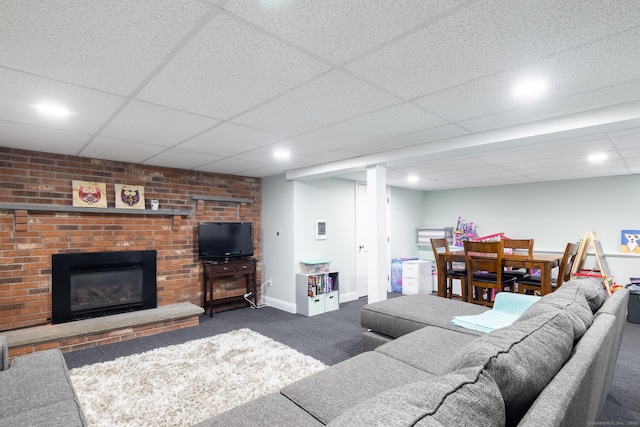 carpeted living room featuring a drop ceiling and a fireplace