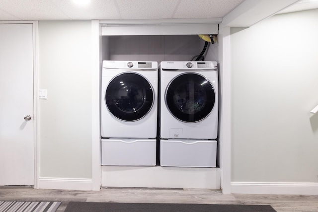 laundry room with light wood-type flooring and washer and dryer