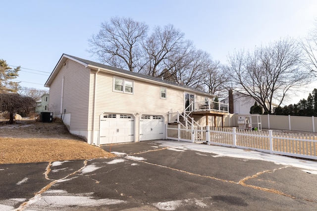 view of front of property with a garage and central AC