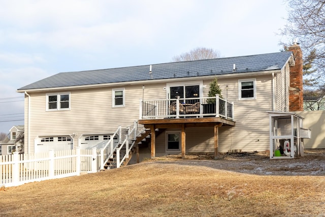 back of house with a garage and a wooden deck