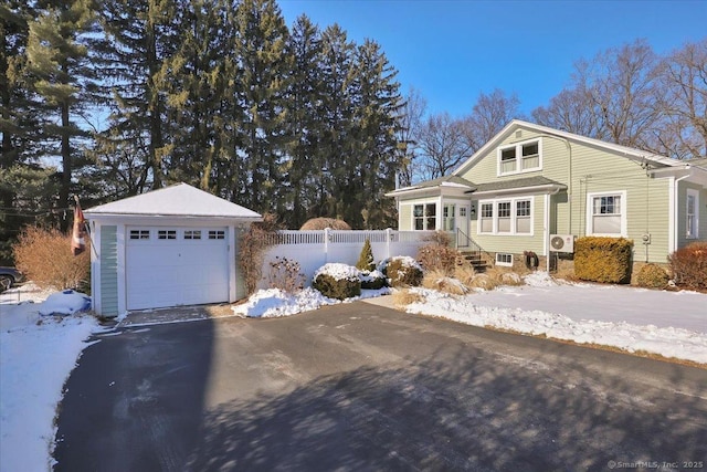 view of snow covered exterior featuring an outbuilding and a garage