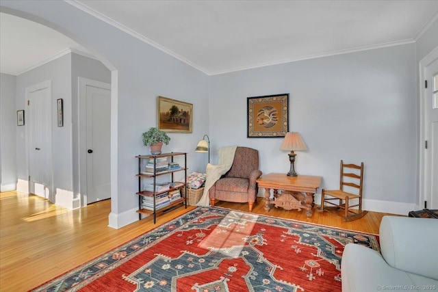 sitting room with hardwood / wood-style floors and crown molding