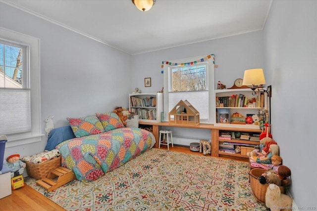 bedroom with crown molding and light wood-type flooring