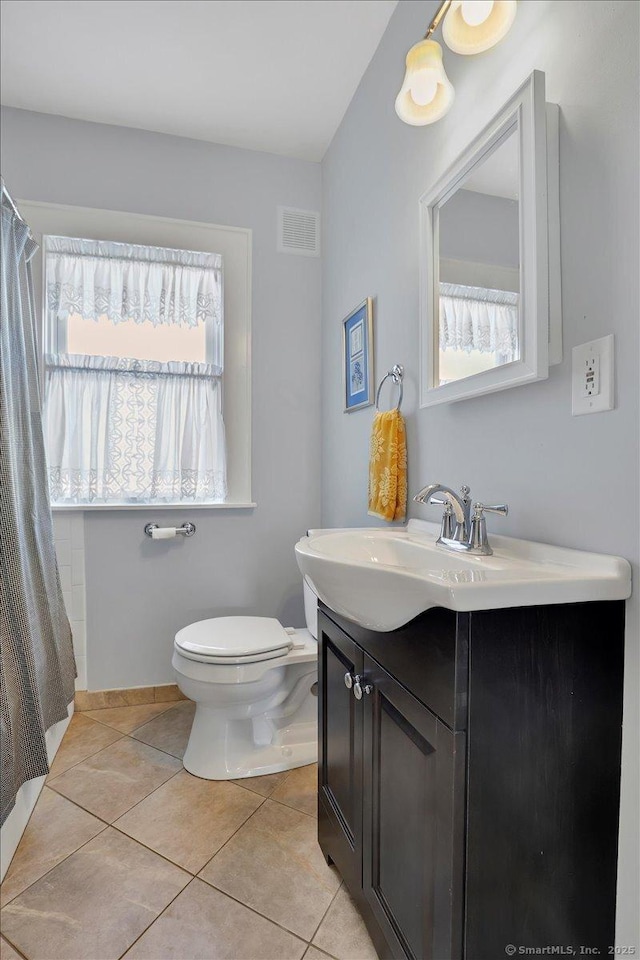 bathroom with vanity, a healthy amount of sunlight, tile patterned floors, and toilet