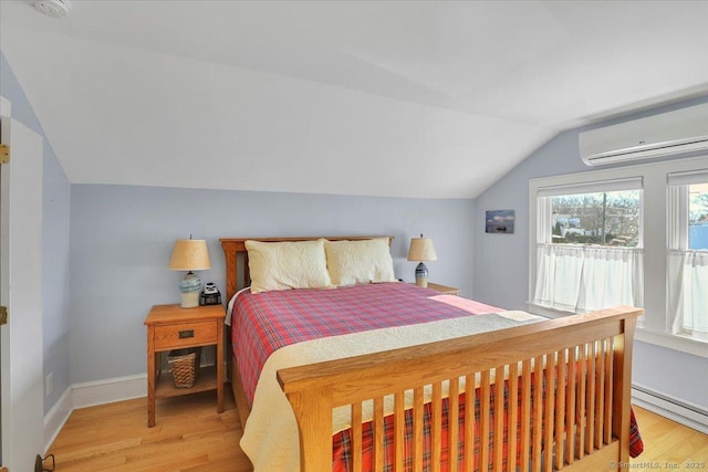 bedroom with a wall mounted air conditioner, hardwood / wood-style flooring, vaulted ceiling, and baseboard heating