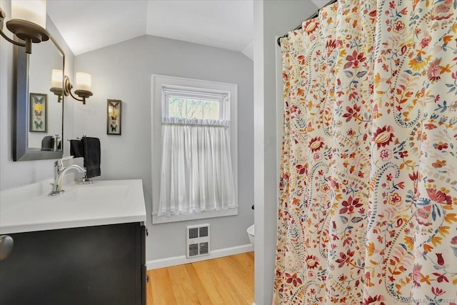 bathroom with lofted ceiling, toilet, vanity, curtained shower, and hardwood / wood-style flooring