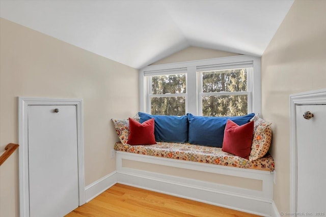 sitting room with vaulted ceiling and wood-type flooring