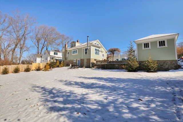 view of snow covered back of property