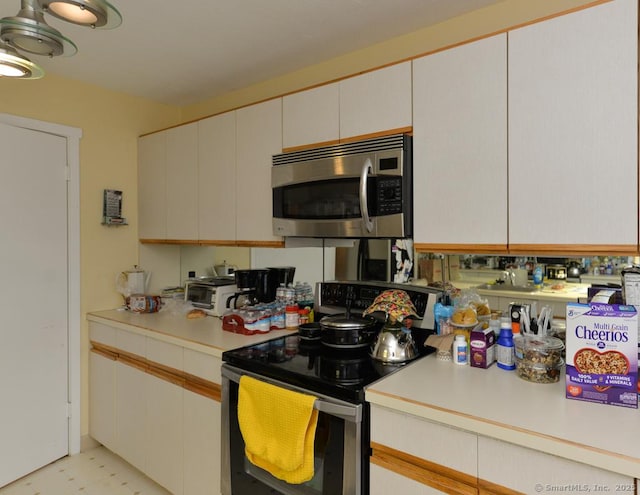 kitchen featuring stainless steel appliances and white cabinetry