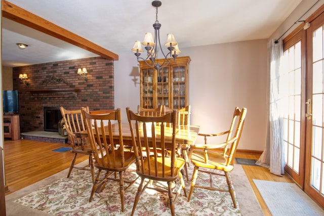 dining space featuring french doors, a fireplace, and light hardwood / wood-style flooring