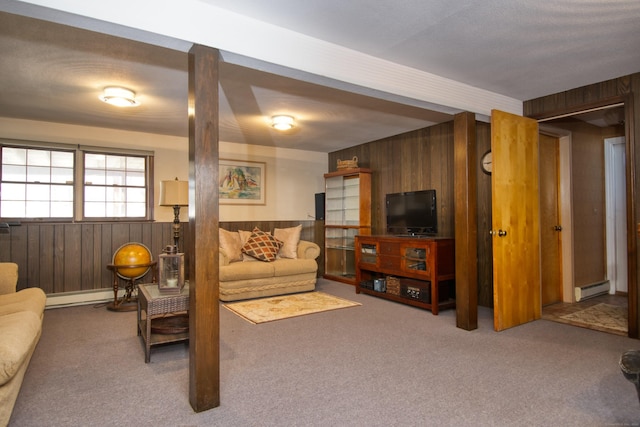 carpeted living room with a baseboard heating unit and wood walls