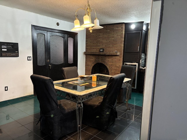 tiled dining room featuring a brick fireplace, a chandelier, and a textured ceiling