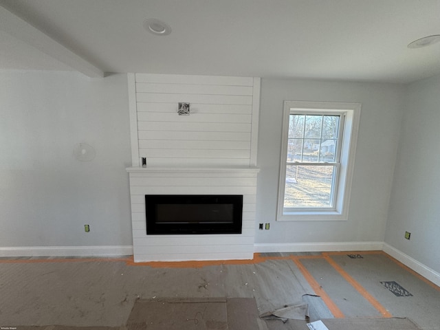 unfurnished living room with a large fireplace, wood finished floors, visible vents, and baseboards