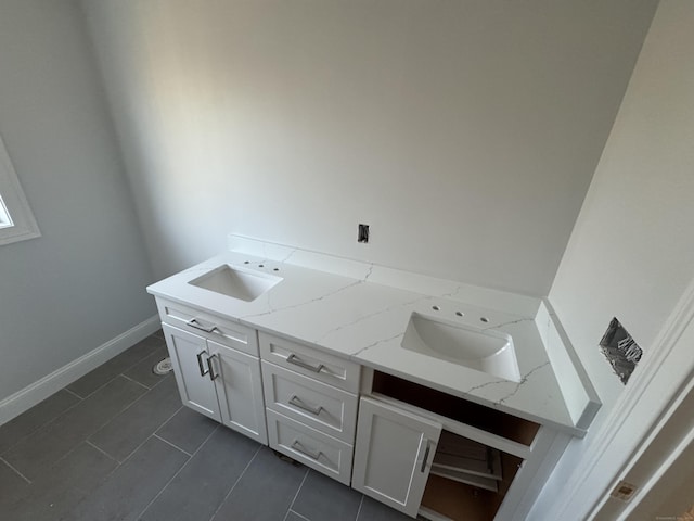 clothes washing area featuring a sink and baseboards