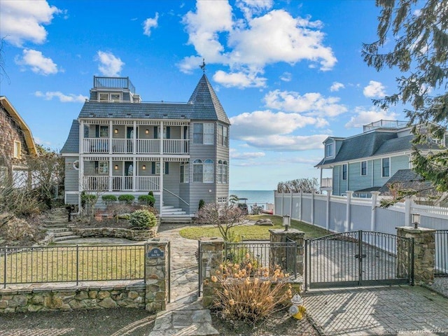 view of front facade featuring covered porch, a water view, and a balcony