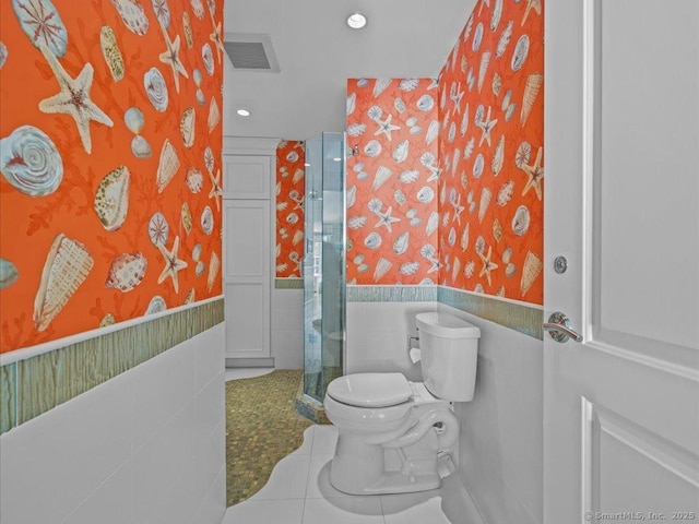 bathroom featuring toilet, tile walls, tile patterned floors, and an enclosed shower