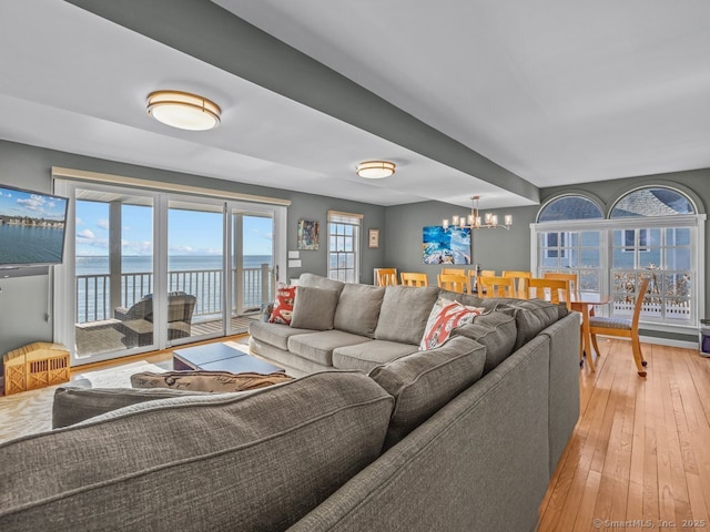 living room featuring a water view, an inviting chandelier, and hardwood / wood-style flooring