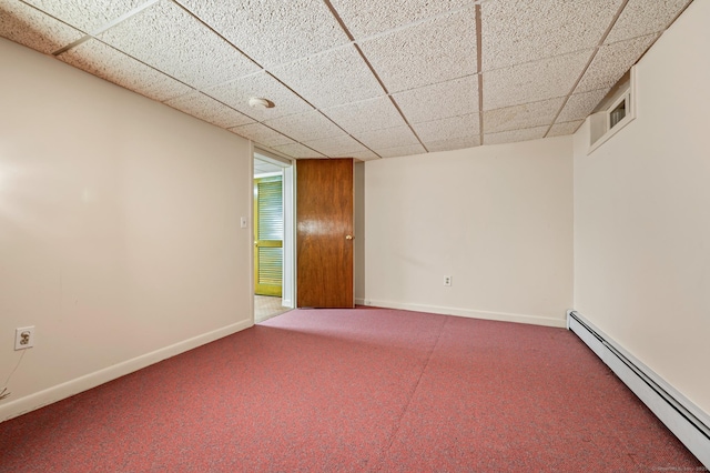 carpeted spare room with a baseboard heating unit