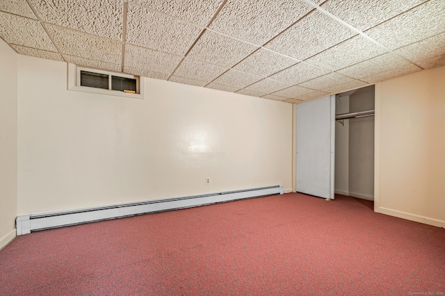 basement featuring a baseboard radiator, carpet floors, and a drop ceiling