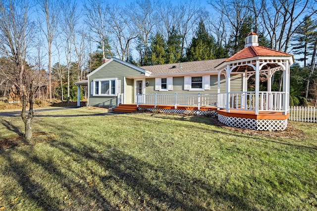 exterior space with a gazebo, a wooden deck, and a front lawn