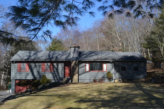 ranch-style house featuring a garage and a front lawn