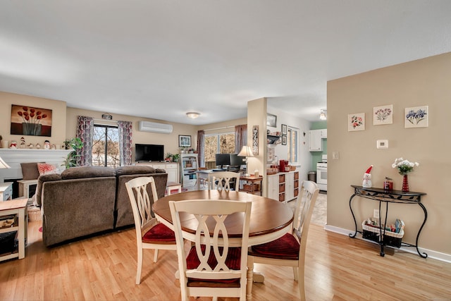 dining area with light hardwood / wood-style floors and a wall mounted AC