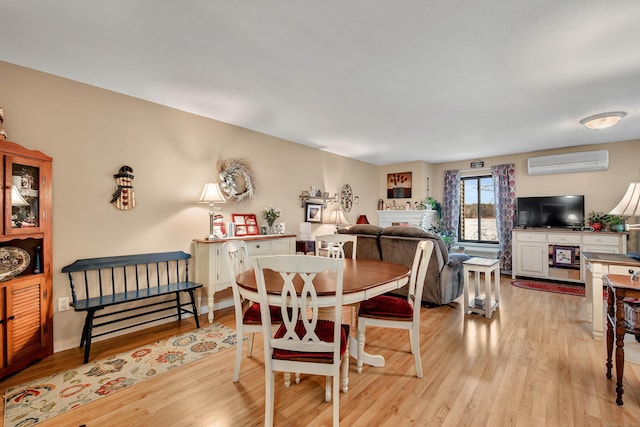 dining space featuring light hardwood / wood-style flooring and a wall unit AC