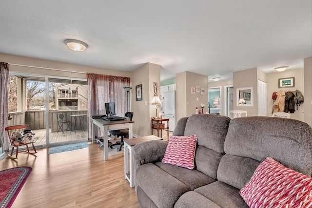 living room with a textured ceiling and light wood-type flooring