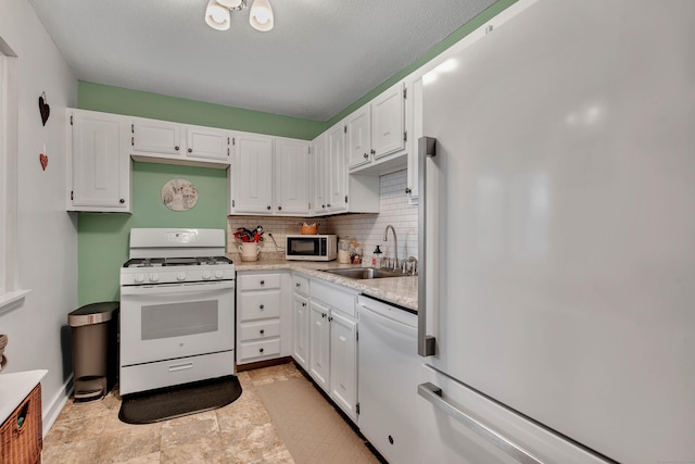 kitchen featuring tasteful backsplash, sink, white appliances, and white cabinets