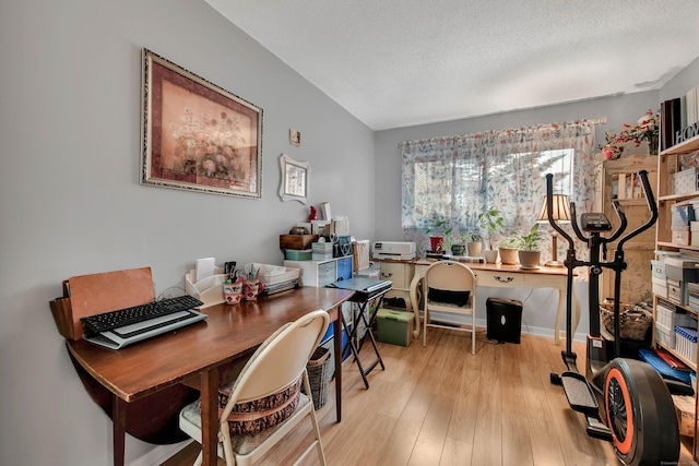 home office with a textured ceiling and light hardwood / wood-style floors