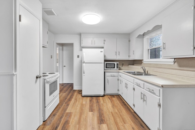 kitchen with white cabinetry, sink, light hardwood / wood-style floors, and white appliances