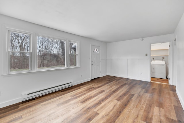 interior space featuring a baseboard heating unit, washer / dryer, and light hardwood / wood-style floors