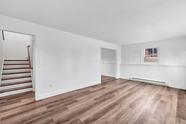 unfurnished room with a baseboard heating unit and hardwood / wood-style flooring