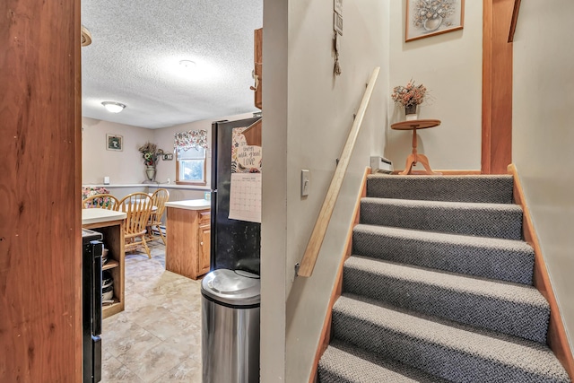 stairs with a textured ceiling