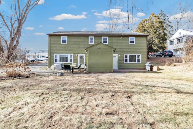 rear view of house featuring a lawn and a patio