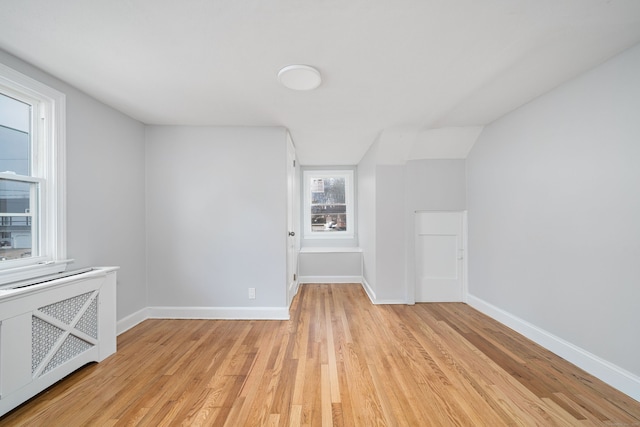 interior space with lofted ceiling, light hardwood / wood-style flooring, and radiator heating unit