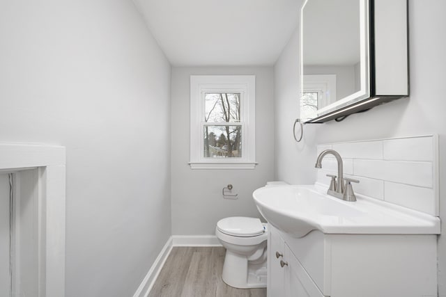 bathroom featuring toilet, vanity, tasteful backsplash, and hardwood / wood-style floors