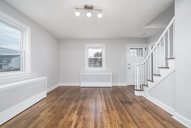 foyer with dark wood-type flooring and radiator heating unit