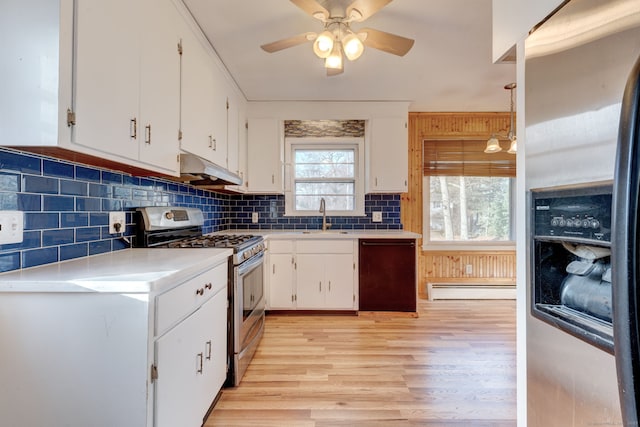 kitchen with stainless steel appliances, sink, white cabinetry, and decorative light fixtures