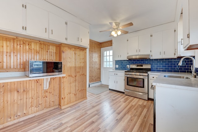 kitchen with stainless steel range with gas stovetop, a baseboard heating unit, ceiling fan, white cabinets, and sink