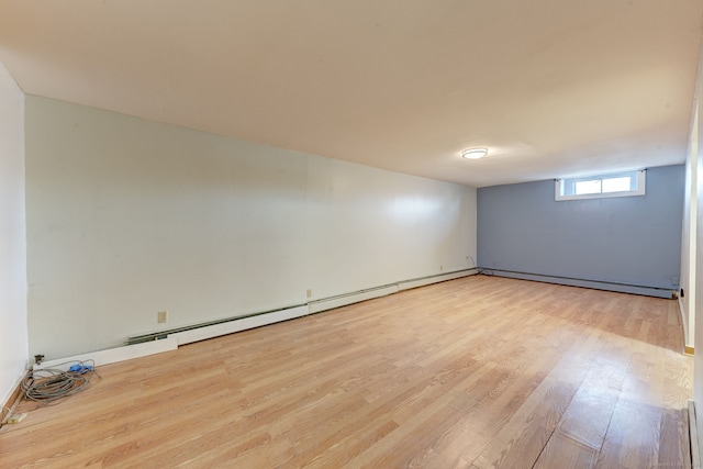 spare room featuring light wood-type flooring and a baseboard radiator